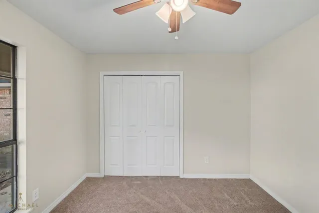 an empty room with a chandelier fan
