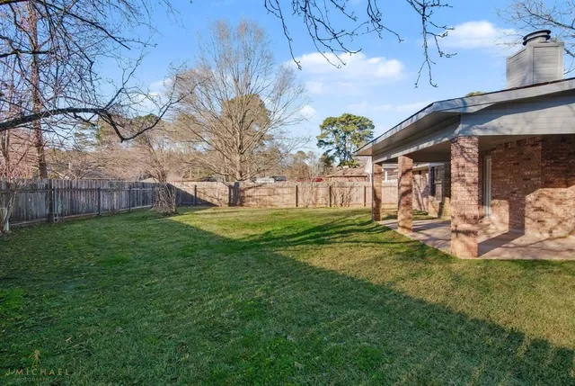 a view of a house with backyard and a tree
