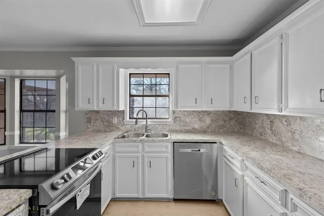 a kitchen with stainless steel appliances granite countertop a sink stove and cabinets