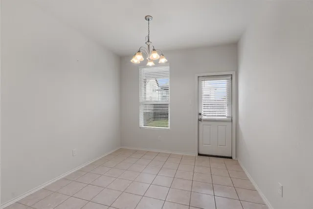 an empty room with windows and chandelier