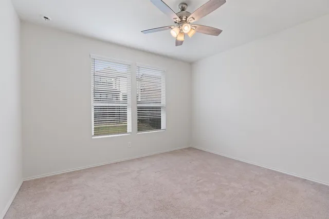 an empty room with a window and a fan