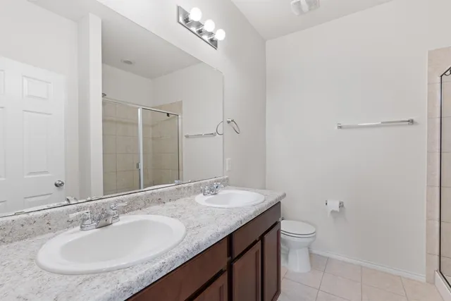 a bathroom with a granite countertop sink a toilet and a mirror