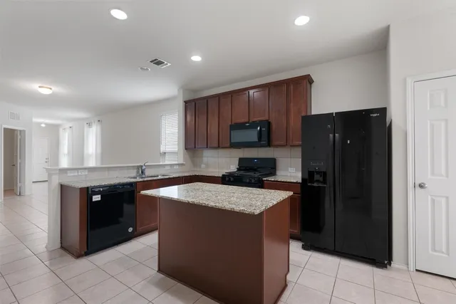 a kitchen with a refrigerator sink and cabinets