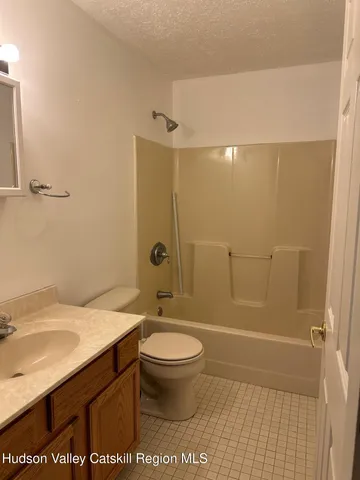 a bathroom with a granite countertop sink and shower