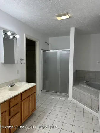 an empty room with a fan & a view of a bathroom