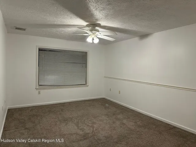 an empty room with a ceiling fan and a window
