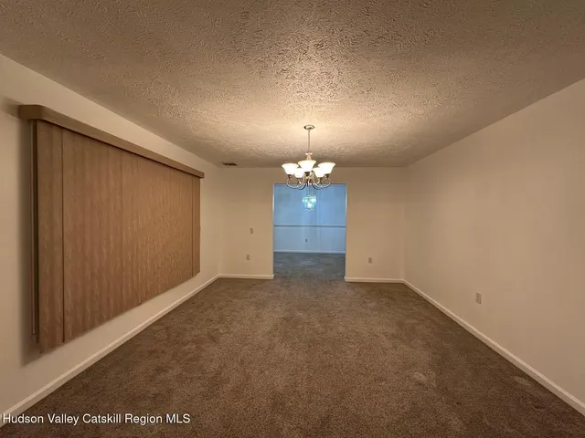 an empty room with fireplace and windows