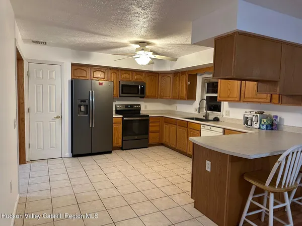 a kitchen with stainless steel appliances granite countertop a refrigerator a sink a stove a microwave and island