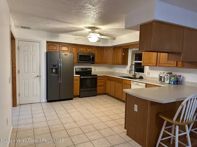 a kitchen with stainless steel appliances granite countertop a refrigerator a sink a stove a microwave and island