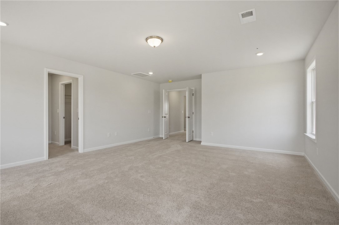 557 Hydrangea Street, Unit LOT 46 Seneca, SC 29678 - Photo 19 of 37 A spacious room offers ample natural light and plush carpeting throughout.