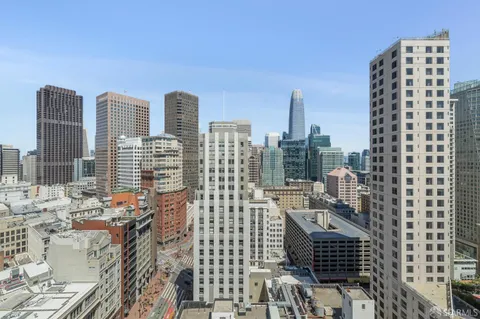 a view of a room with wooden floor and large windows