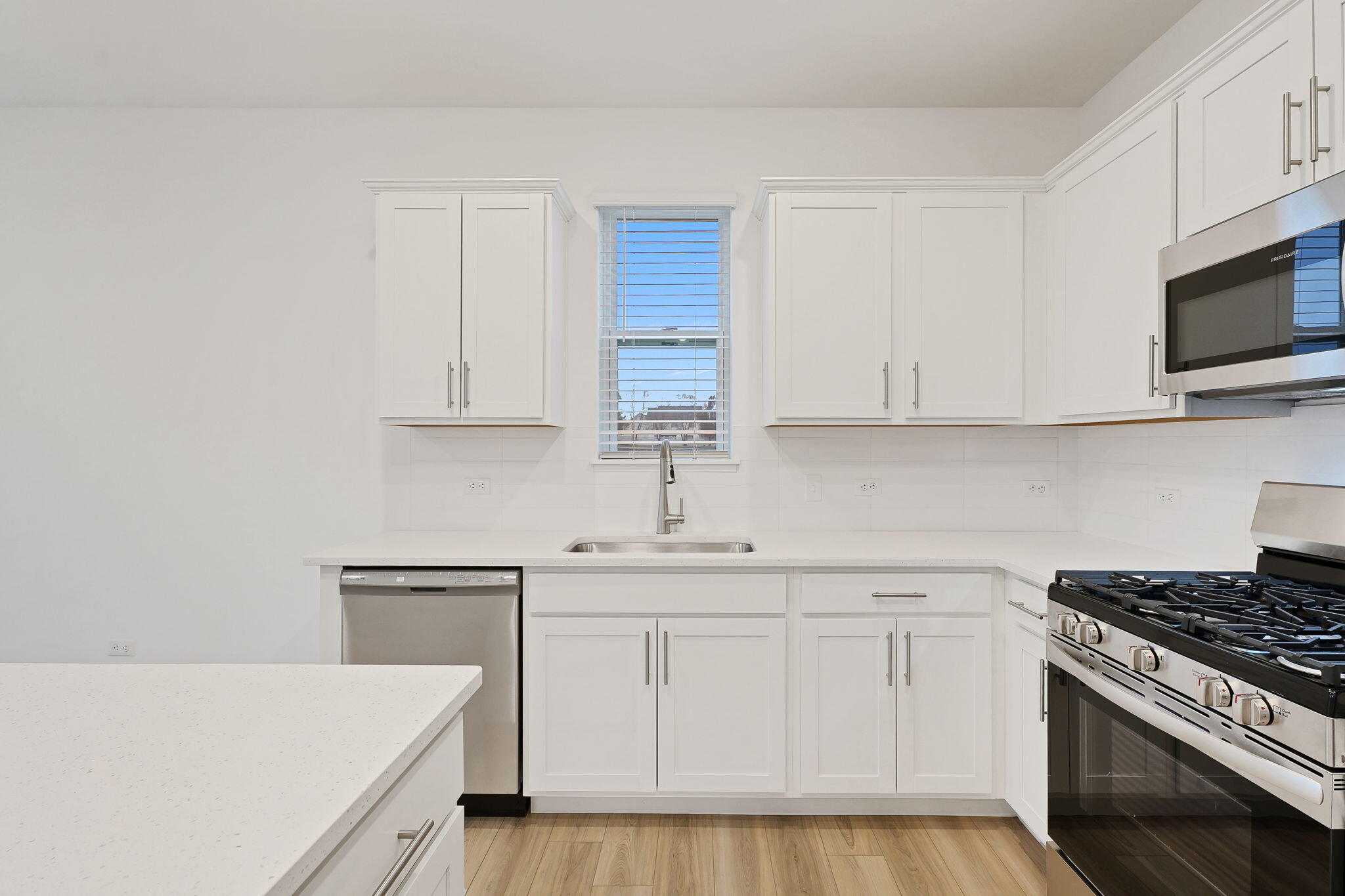 12541 Virginia Street Crown Point, IN 46307 - Photo 12 of 24 a kitchen with white cabinets and white appliances