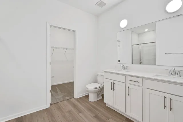 a bathroom with a sink a toilet a large mirror and vanity