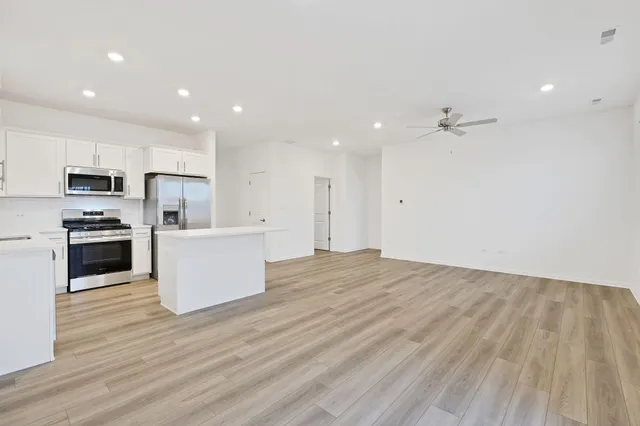a view of kitchen with wooden floor and electronic appliances