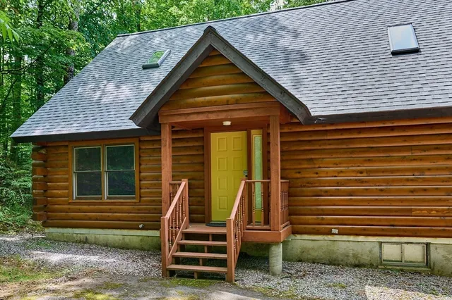 a backyard of a house with large trees and plants