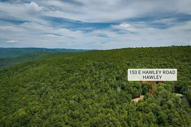a sign that is sitting in the grass next to a large building