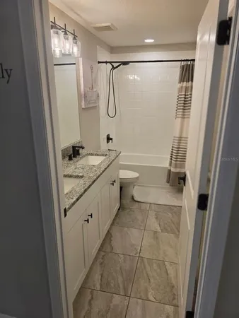 a bathroom with a granite countertop sink toilet and shower