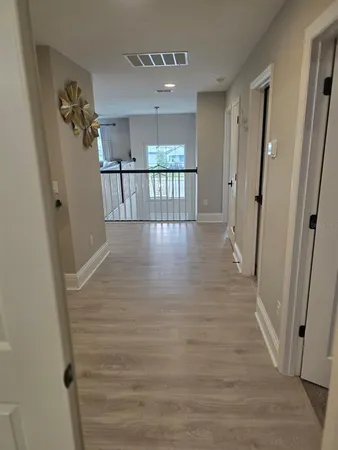 a view of a hallway with wooden floor and staircase