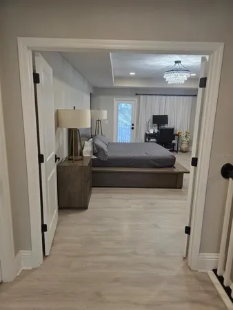 a large bedroom with a bed wooden floor and window