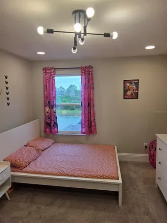 a bedroom with a bed and a chandelier