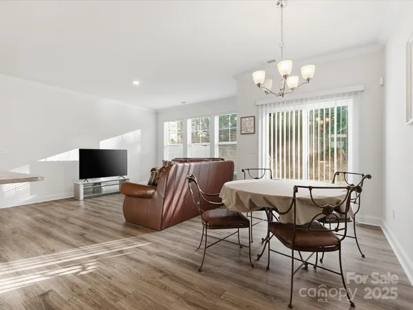 a living room with furniture a chandelier and a flat screen tv