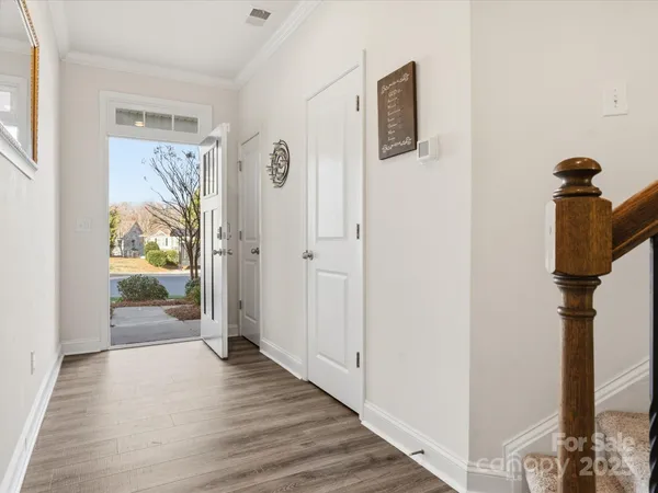a view of a hallway with wooden floor and door