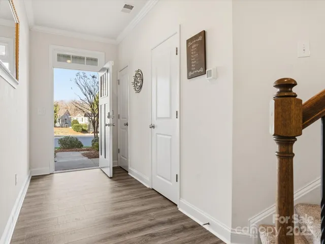 a view of a hallway with wooden floor and door