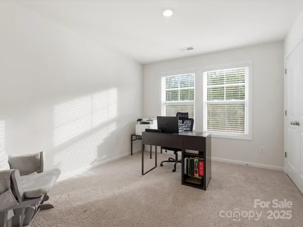 a view of a workspace with furniture and a window