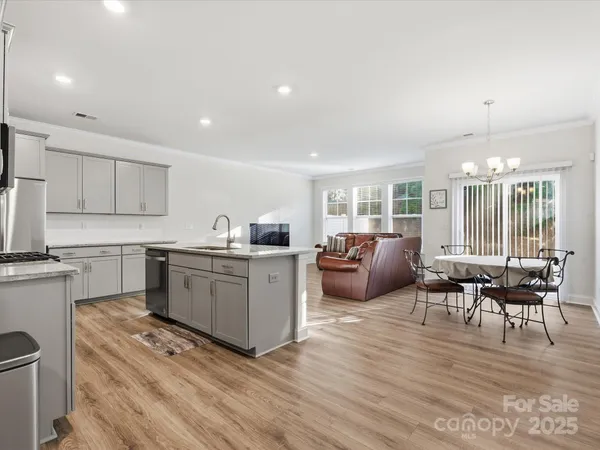 a large white kitchen with lots of counter space a sink and appliances