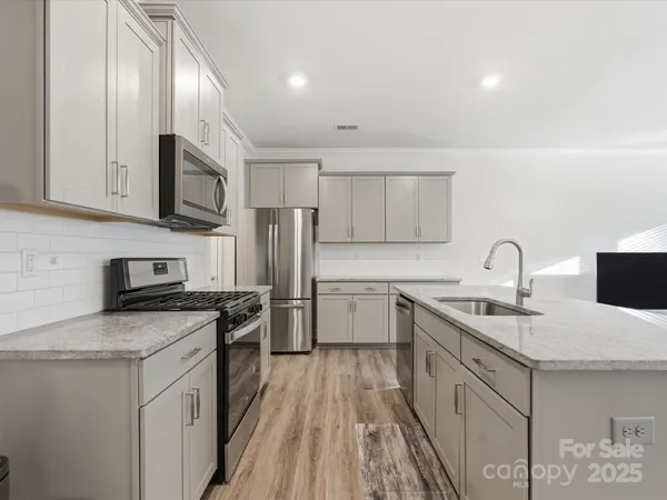 a kitchen with a sink stove and refrigerator