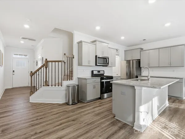 a kitchen with a sink appliances cabinets and a counter top space