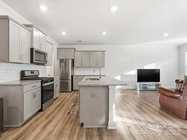 a large kitchen with stainless steel appliances lots of counter space and wooden floor