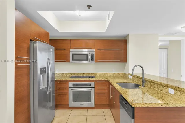 a kitchen with stainless steel appliances granite countertop a sink stove and microwave