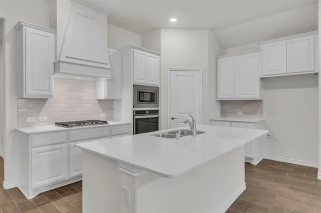 a kitchen with white cabinets and appliances