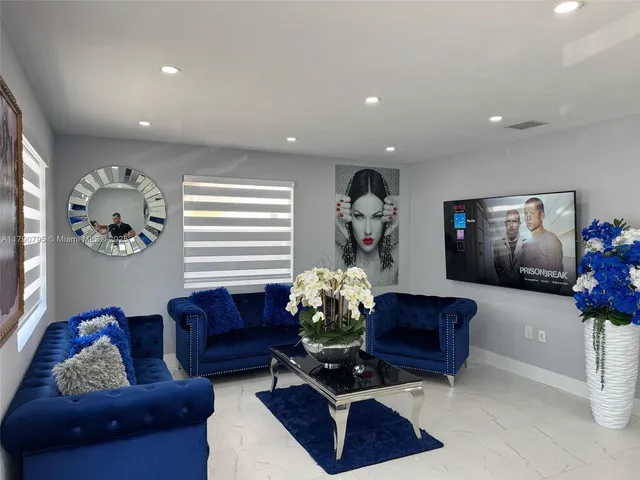 a living room with furniture flowerpot and a chandelier