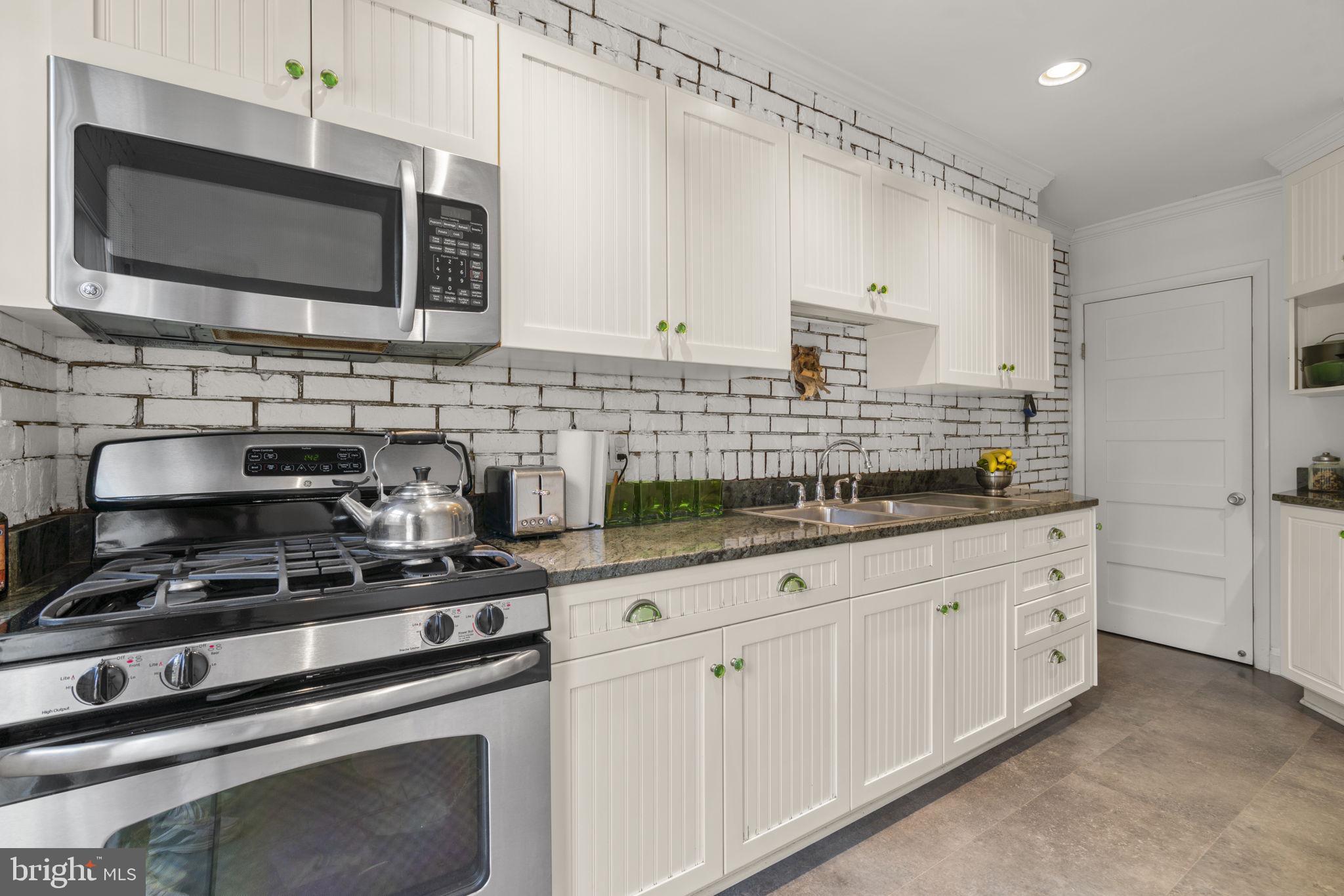 7413 Stanmore Court Baltimore, MD 21212 - Photo 13 of 38 a kitchen with stainless steel appliances granite countertop a stove a sink and a microwave