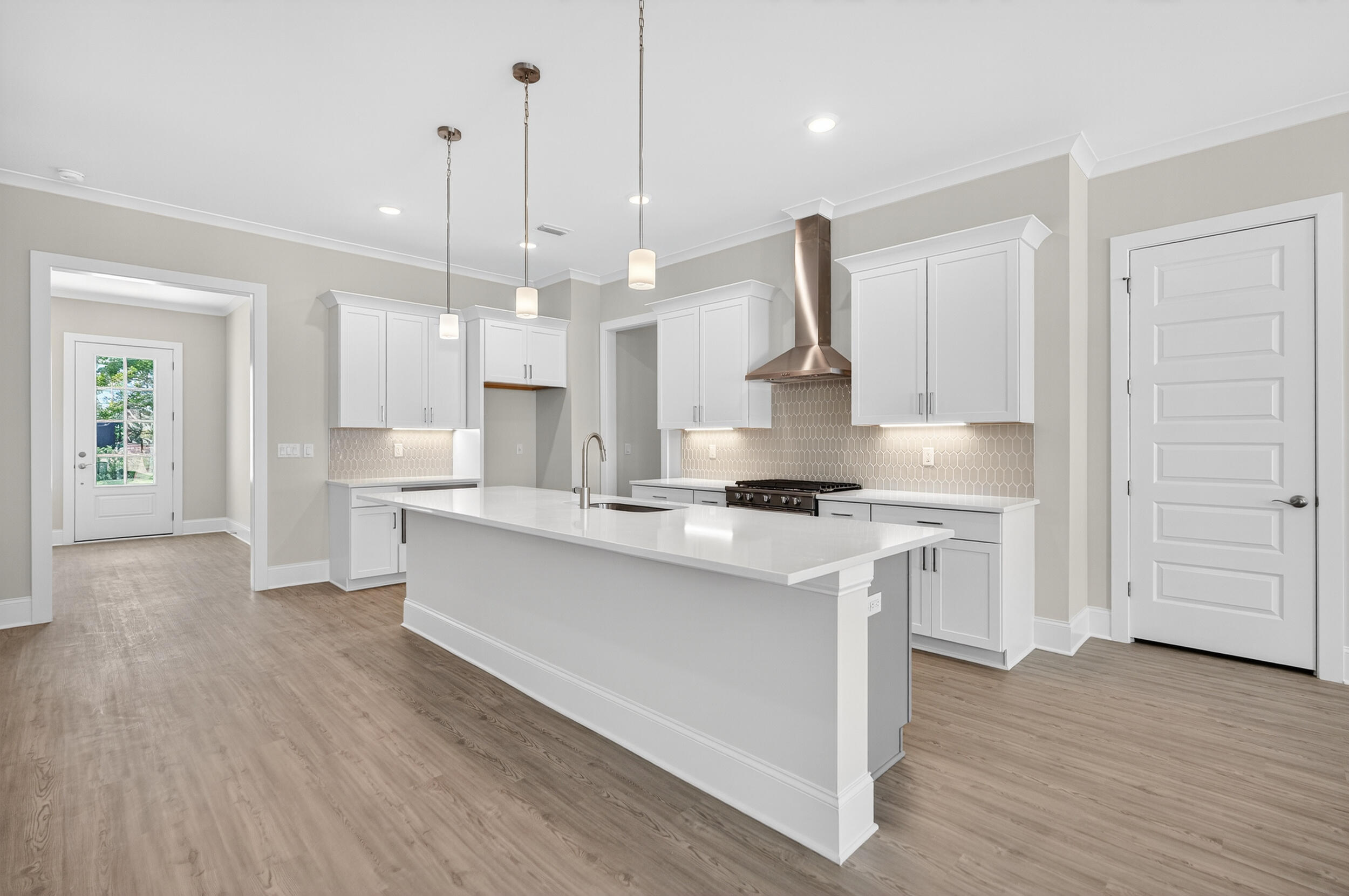 19 North J Hunter's Way, Unit LOT 22 Freeport, FL 32439 - Photo 14 of 48 a large kitchen with stainless steel appliances kitchen island granite countertop a stove a sink a refrigerator and white cabinets with wooden floor