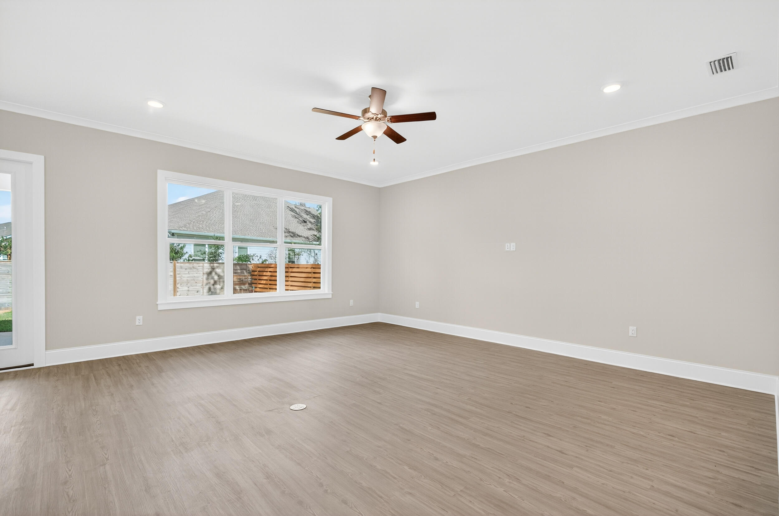 19 North J Hunter's Way, Unit LOT 22 Freeport, FL 32439 - Photo 7 of 48 an empty room with wooden floor ceiling fan and windows