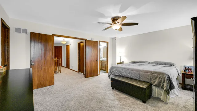 a spacious bedroom with a bed and a chandelier