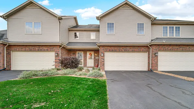 a front view of a house with a garden and plants