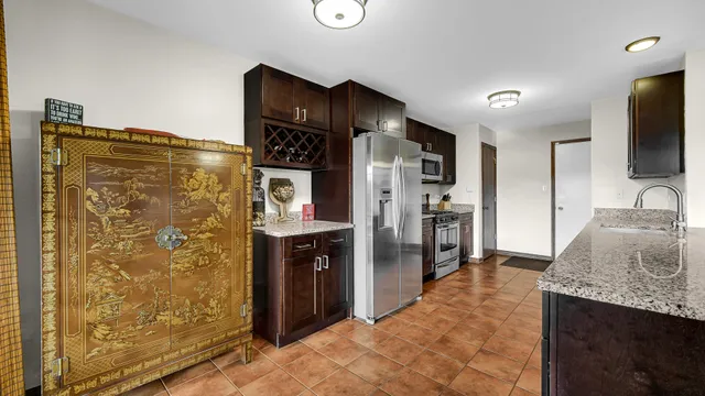 a kitchen with stainless steel appliances granite countertop a refrigerator and a sink