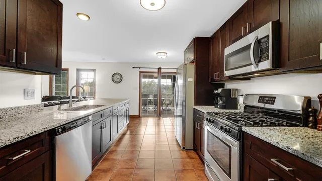 a kitchen with stainless steel appliances granite countertop a stove a sink and a microwave