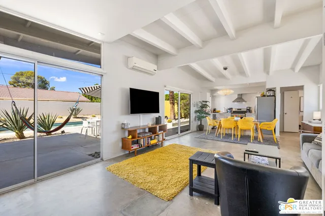 a living room with patio furniture and a flat screen tv