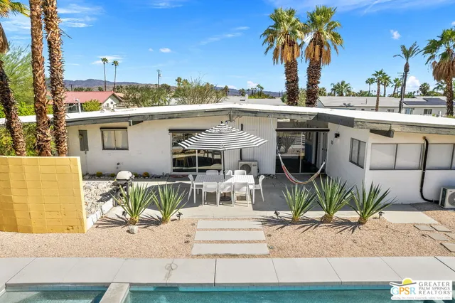 a view of a house with backyard and sitting area