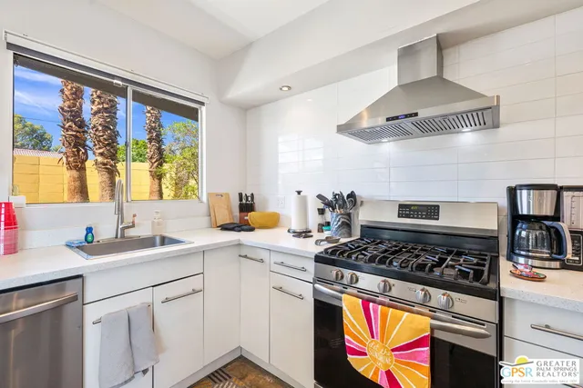 a kitchen with stainless steel appliances a stove a sink and a refrigerator
