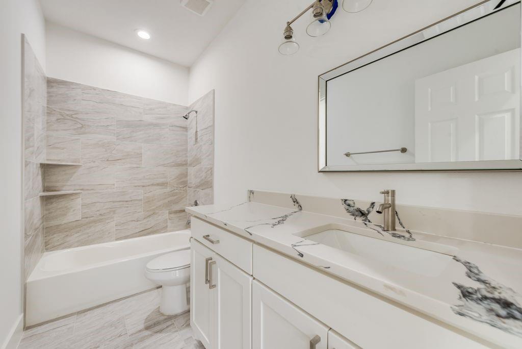 2346 Scott Street Dallas, TX 75215 - Photo 12 of 20 a bathroom with a granite countertop sink a toilet and bathtub