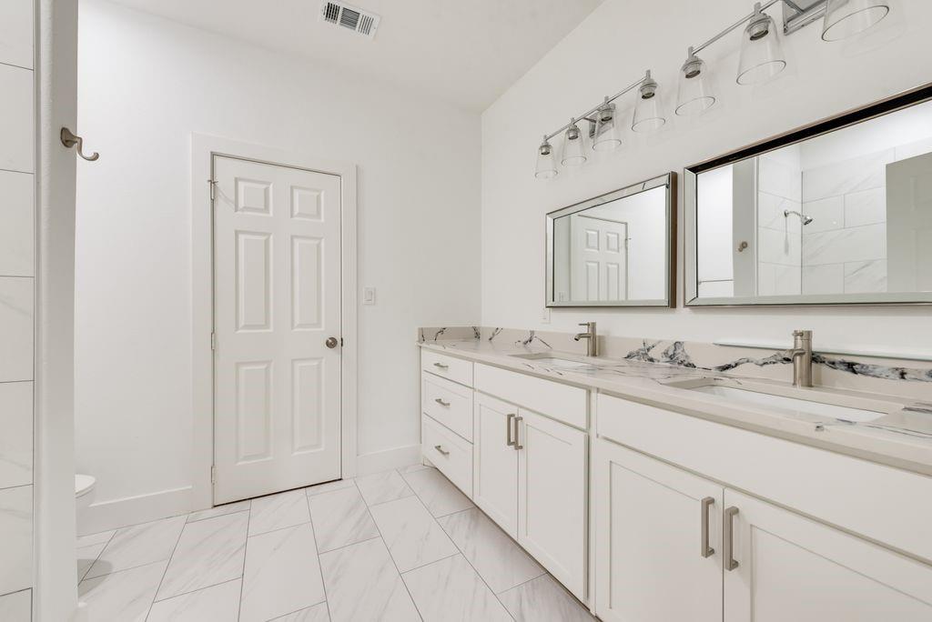 2346 Scott Street Dallas, TX 75215 - Photo 16 of 20 a bathroom with a granite countertop double vanity sink and mirror