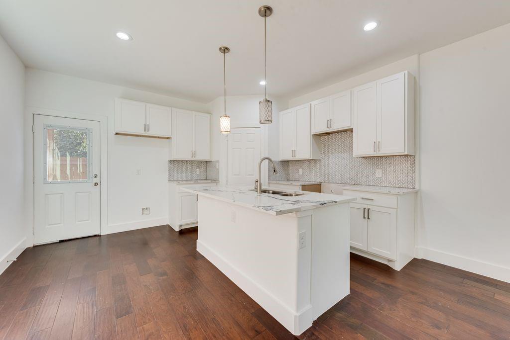 2346 Scott Street Dallas, TX 75215 - Photo 8 of 20 a kitchen with stainless steel appliances granite countertop a stove a sink a refrigerator and white cabinets with wooden floor