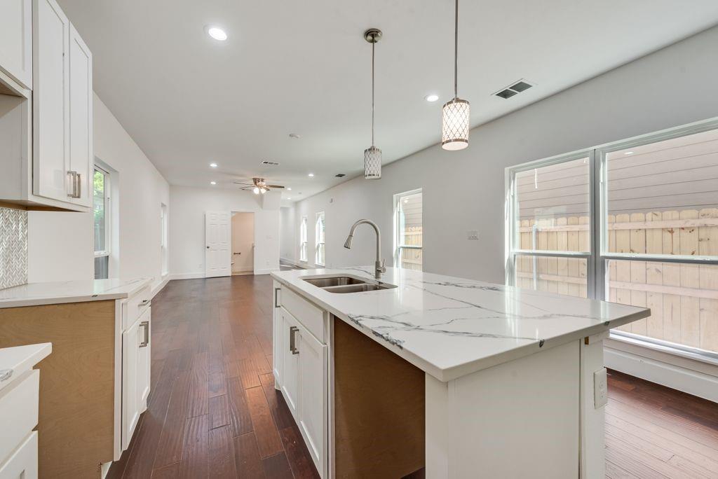 2346 Scott Street Dallas, TX 75215 - Photo 10 of 20 a kitchen with a stove a sink a center island and wooden floor