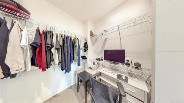 a view of walk in closet with clothes